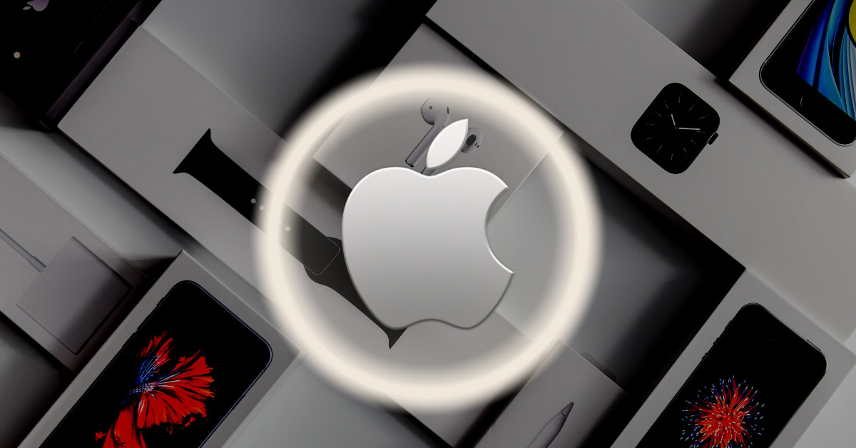 Apple silver logo with silver halo effect around it. Apple marketing products displayed in background.